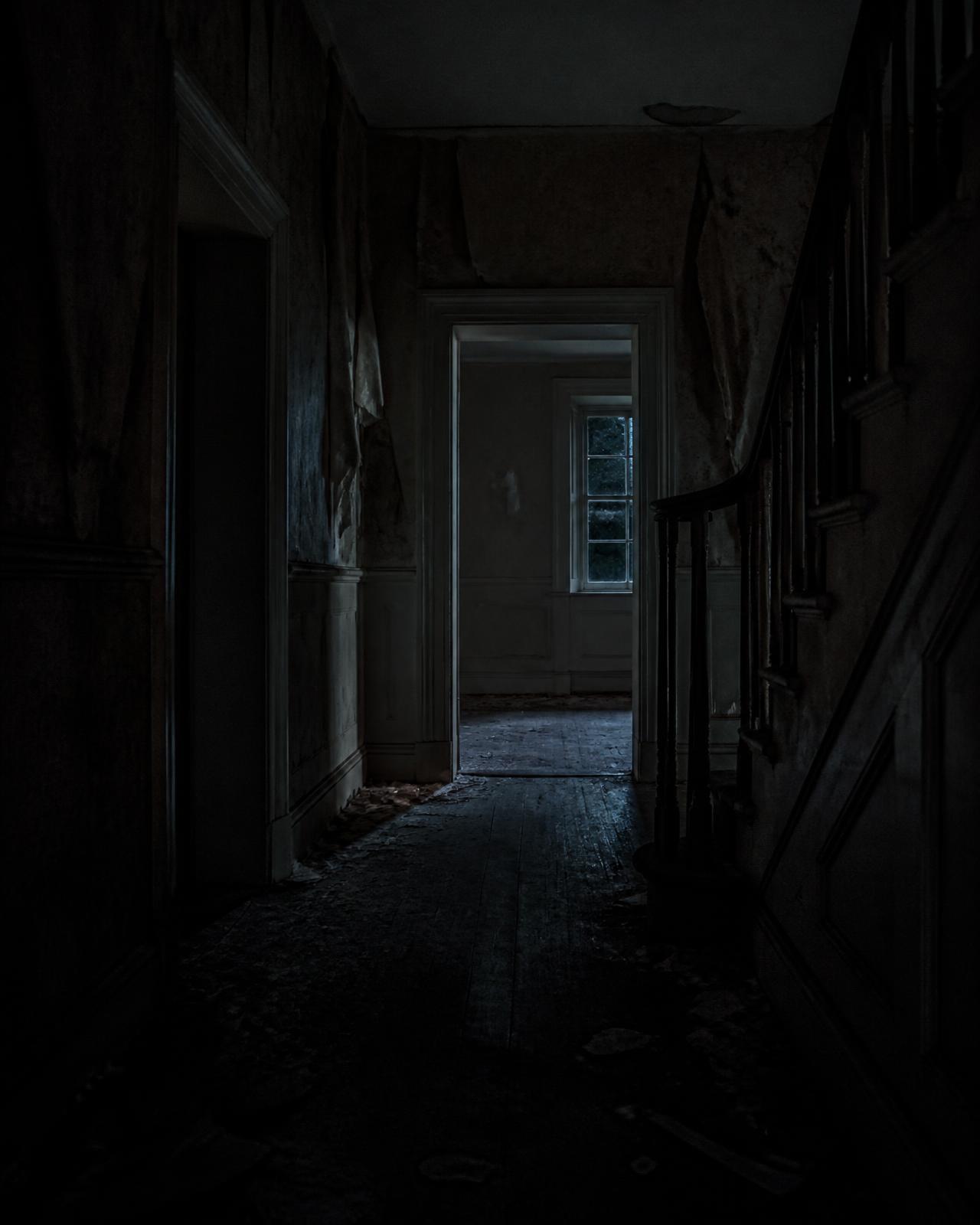 Empty hallway of an abandoned historic mansion at night